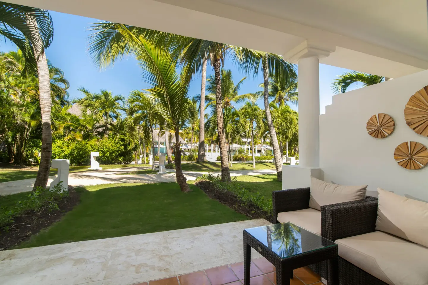 Garden-view terrace of The Level Junior Suite at Melia Caribe Beach Resort with sofa and palms.