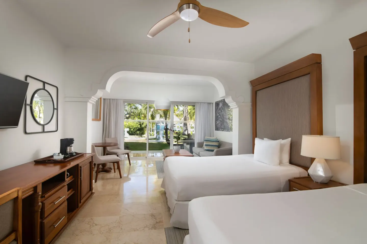 Two beds and garden-facing sitting area in The Level Junior Suite Garden View at Melia Caribe Beach Resort.