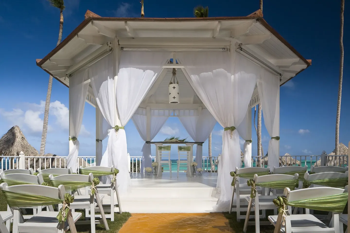 White beachfront wedding gazebo with chairs at Melia Caribe Beach Resort.