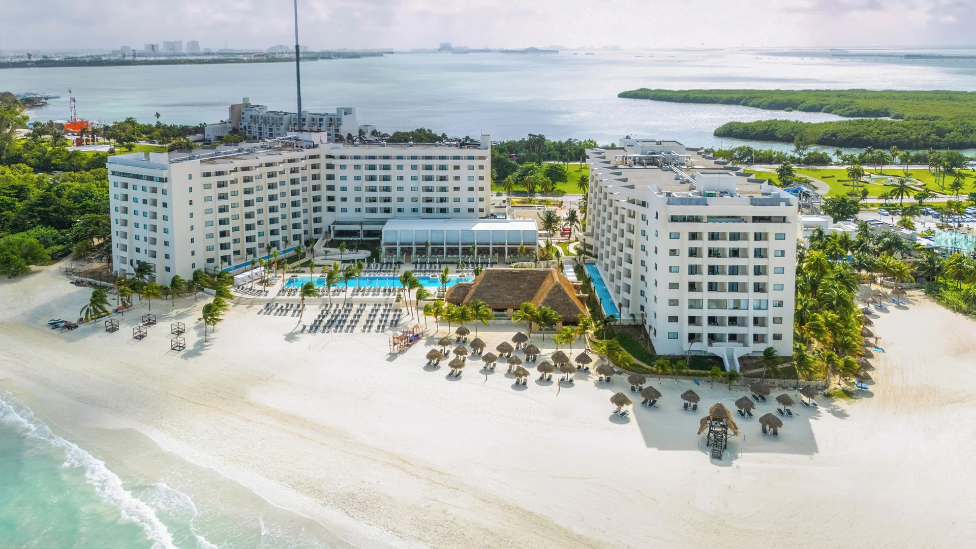 An aerial view of Melia Casa Maya Cancun beside the beach, pools, and lagoon.