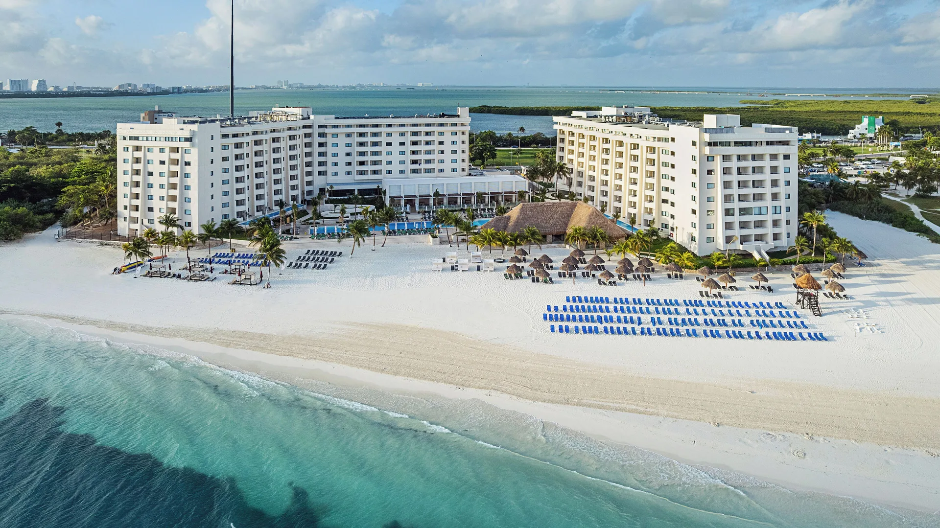 Beachfront hotel towers and rows of loungers face the sea at Melia Casa Maya Cancun.
