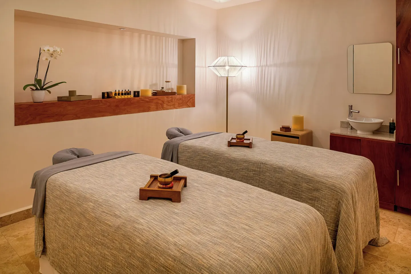 Two-bed spa treatment room with sinks and shelves at Melia Casa Maya Cancun.