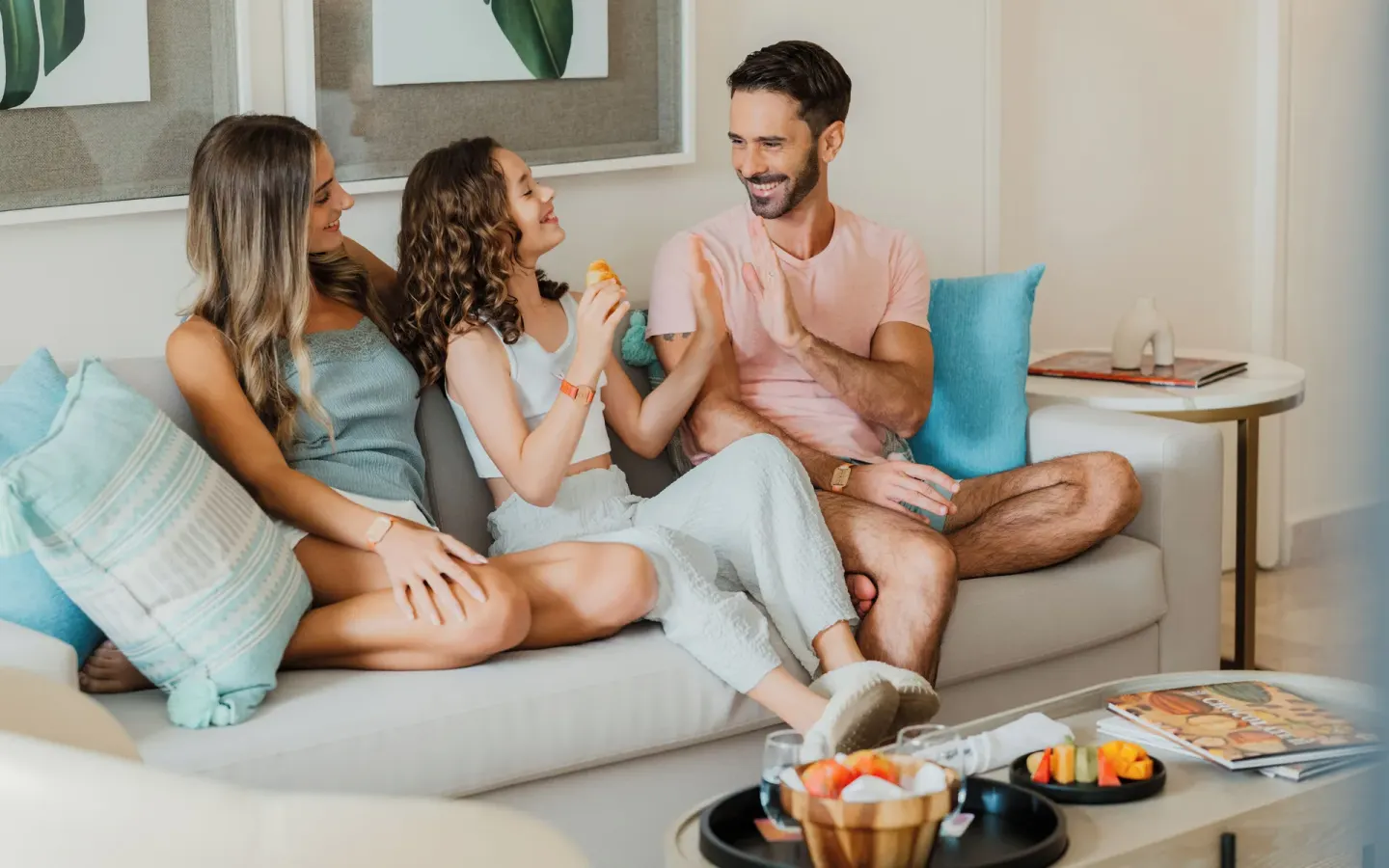 Family relaxing on a sofa with snacks in a suite at Melia Casa Maya Cancun.