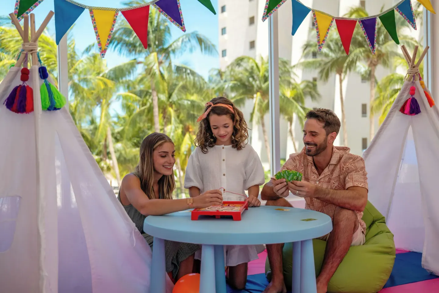 Family playing a tabletop game in a kids area at Melia Casa Maya Cancun.
