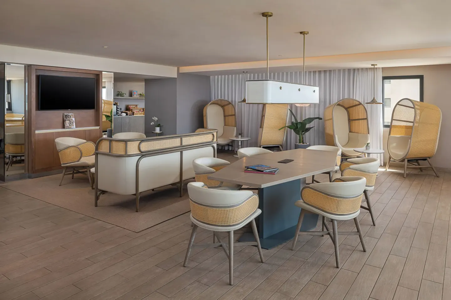 A shared lounge and dining table area with cane chairs at Melia Casa Maya Cancun.