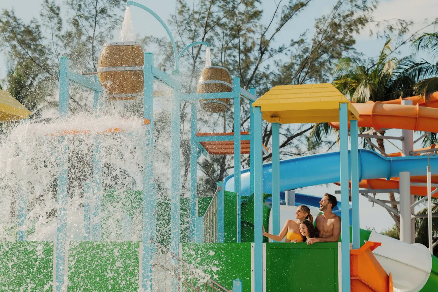 Guests watch splashing buckets and colorful water slides at Melia Casa Maya Cancun.