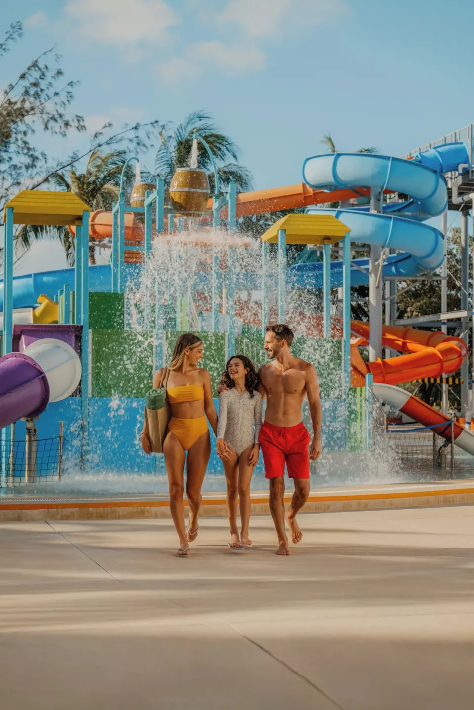 Family walks past the splash park and water slides at Melia Casa Maya Cancun.