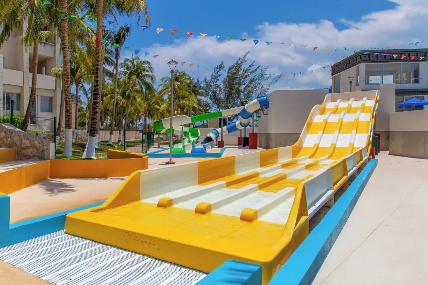 Wide yellow multi-lane water slide in the resort water park at Melia Casa Maya Cancun.