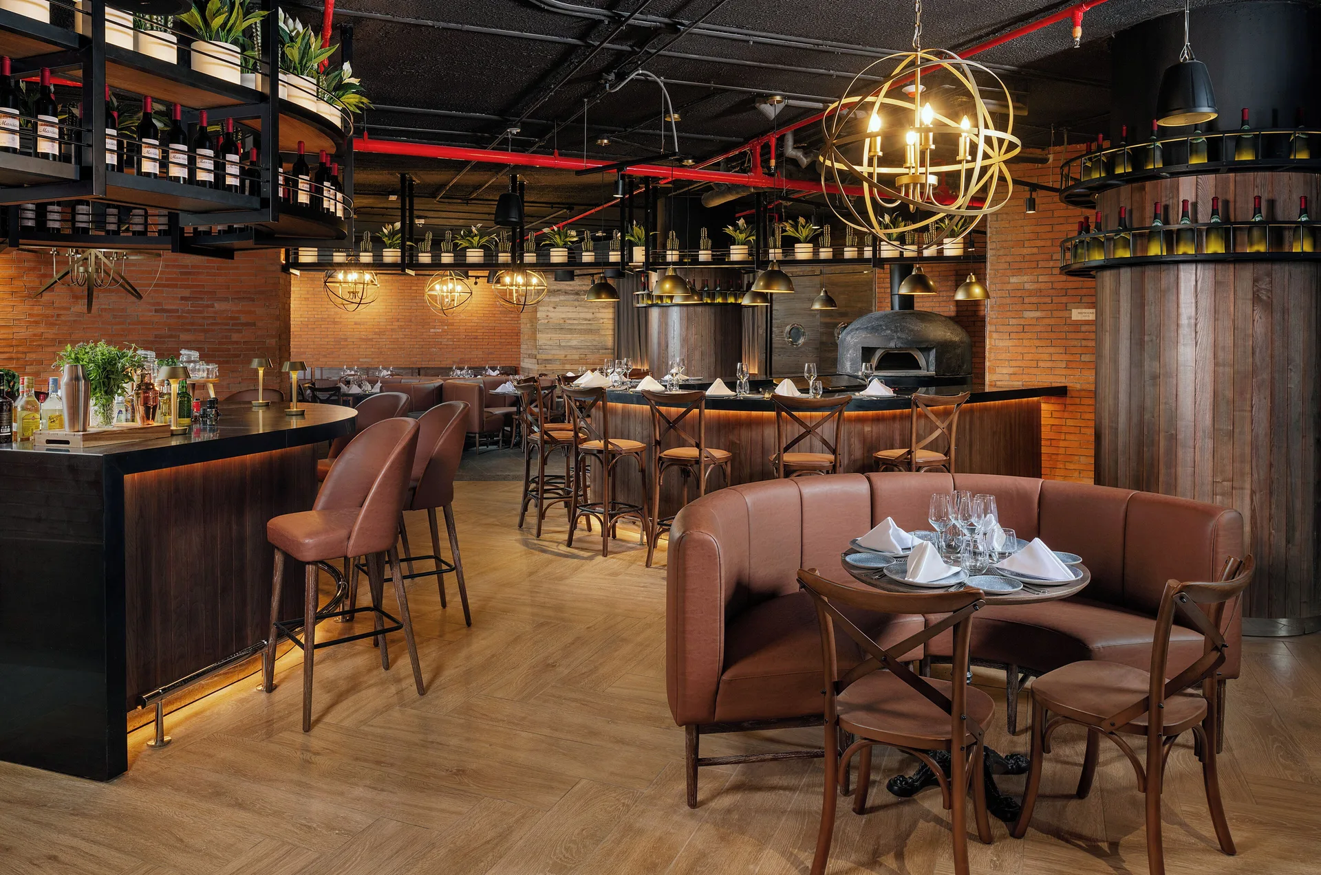 Italian-style restaurant with bar, brick walls, and pizza oven at Melia Casa Maya Cancun.