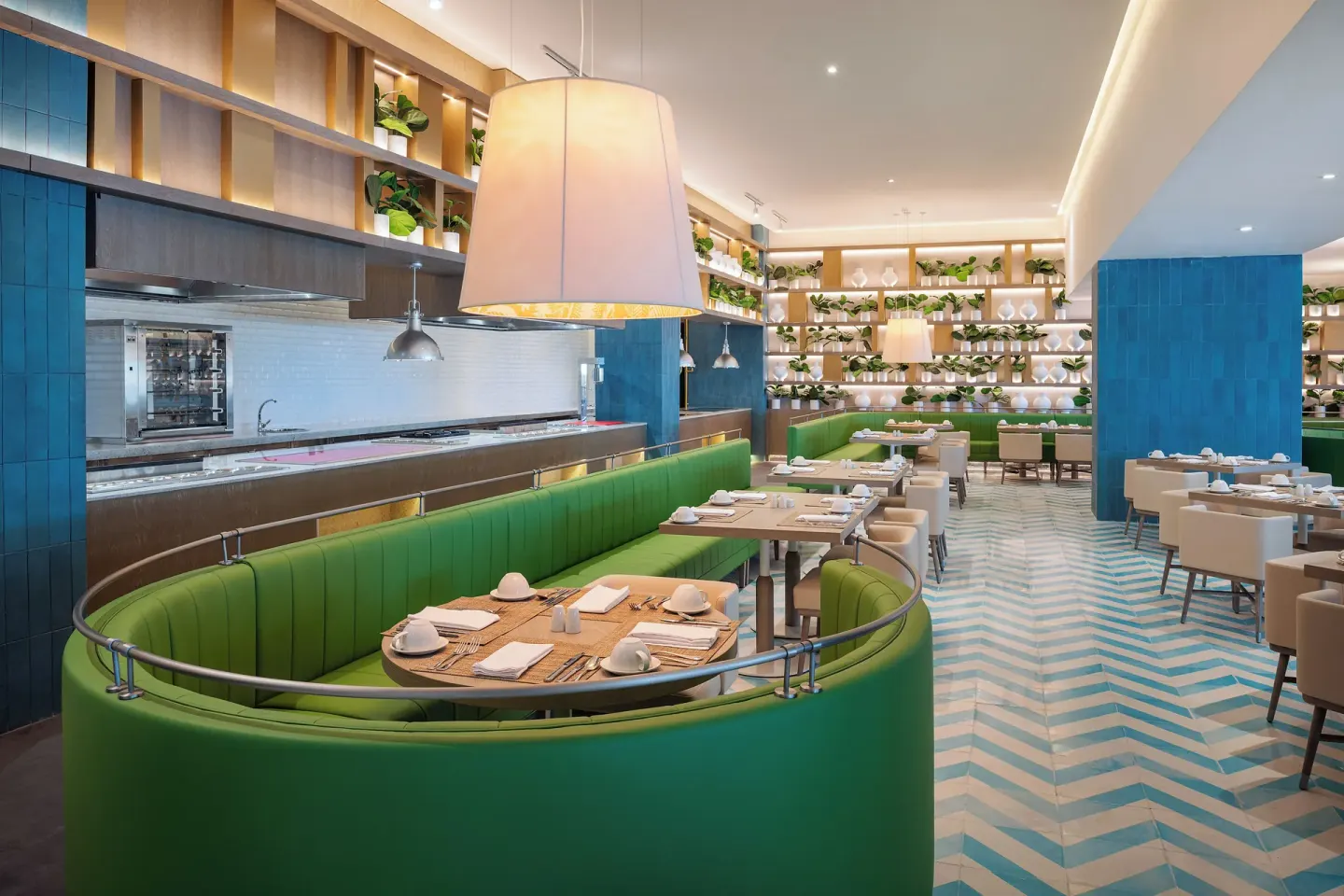 Green banquette dining room with open kitchen at Melia Casa Maya Cancun.