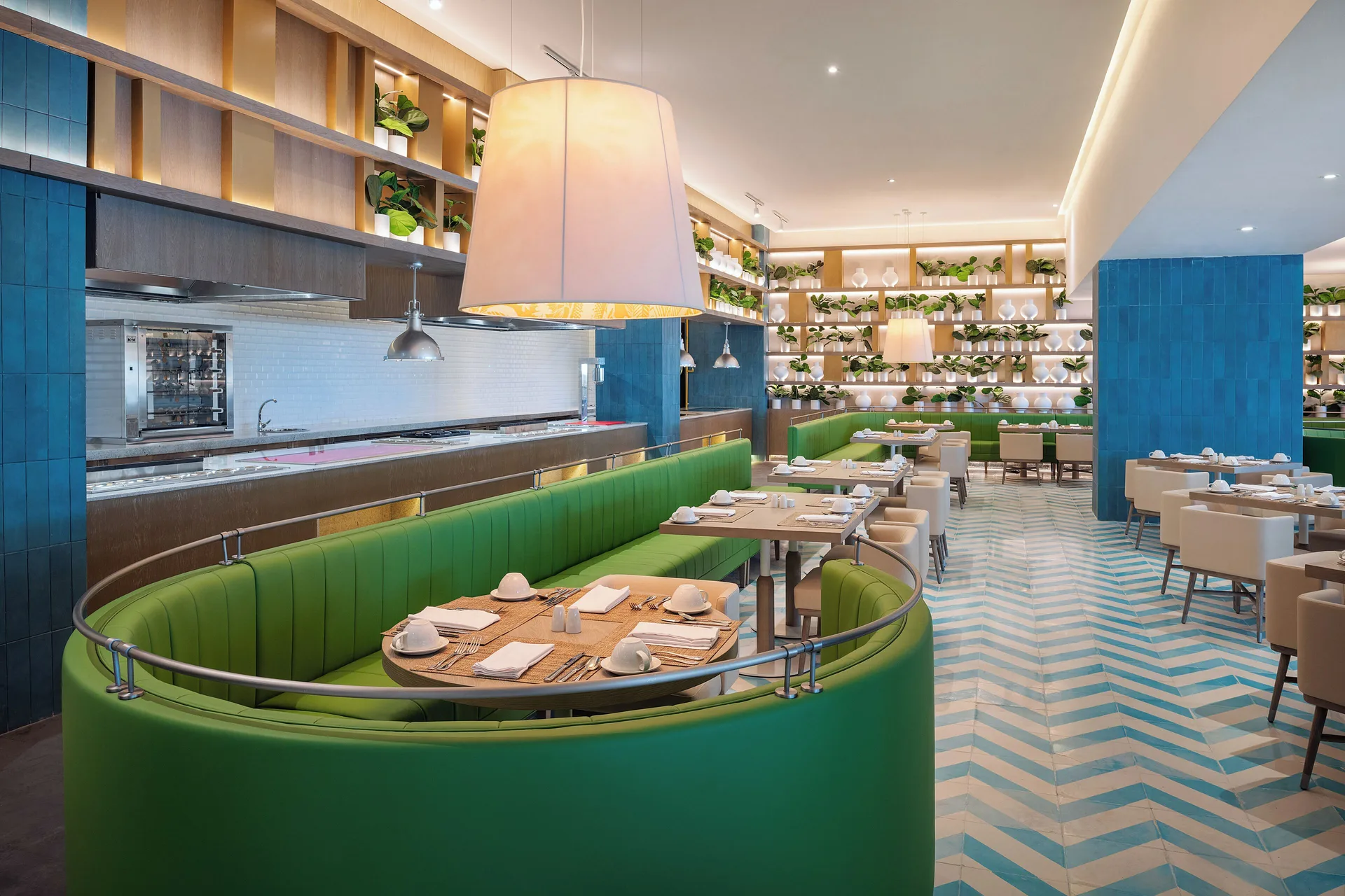 Green banquette dining room with open kitchen at Melia Casa Maya Cancun.