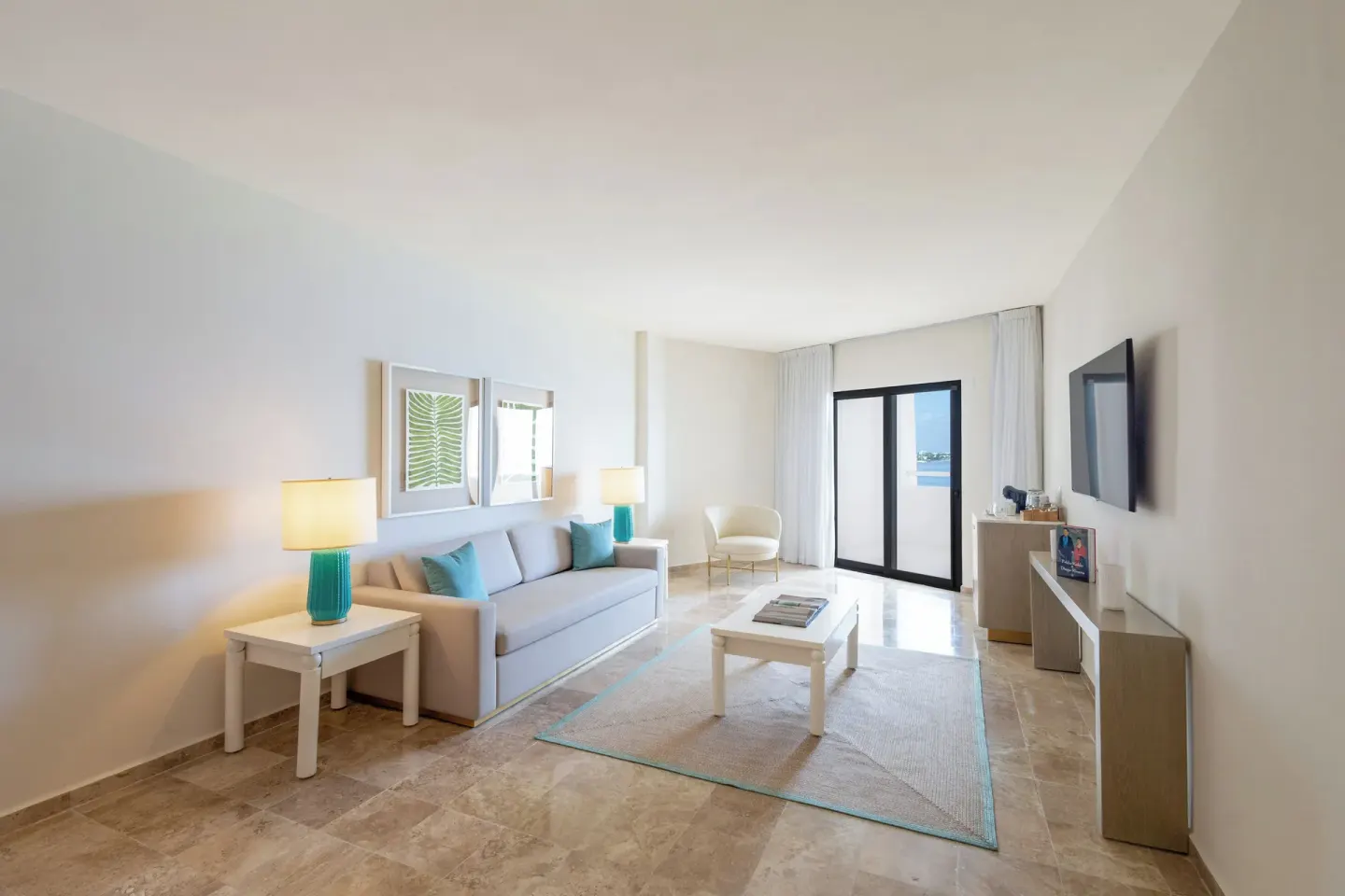 The Level Grand Suite living area with sofa, coffee table, TV, and balcony doors at Melia Casa Maya Cancun.