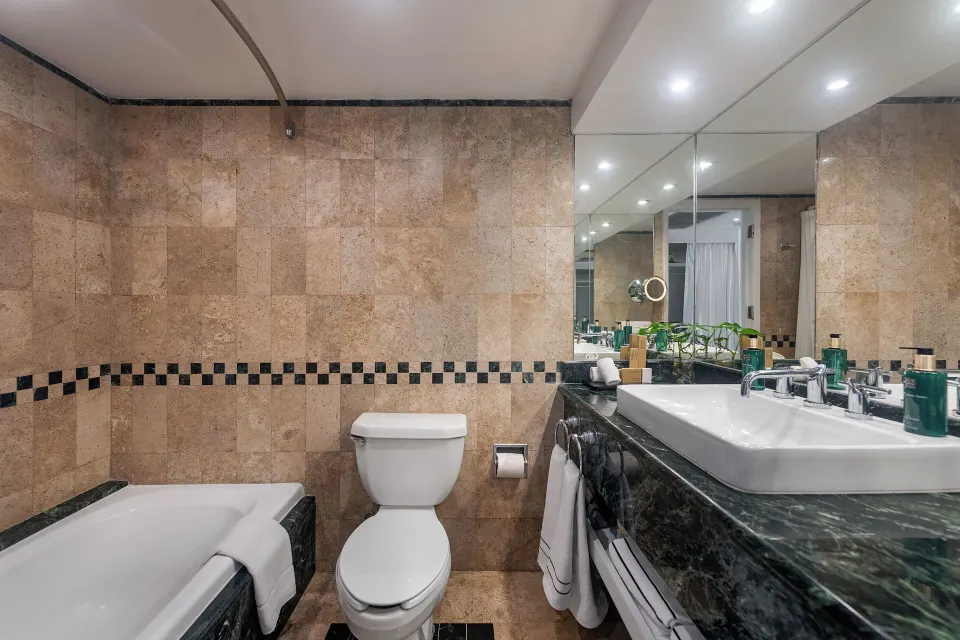 Full bathroom showing bathtub, toilet and marble counter with sink at Melia Cozumel