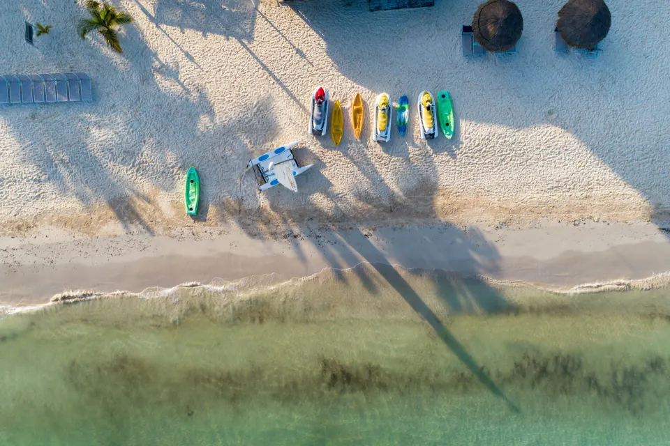 Aerial view of colorful kayaks and paddleboats lined on the beach at Melia Cozumel