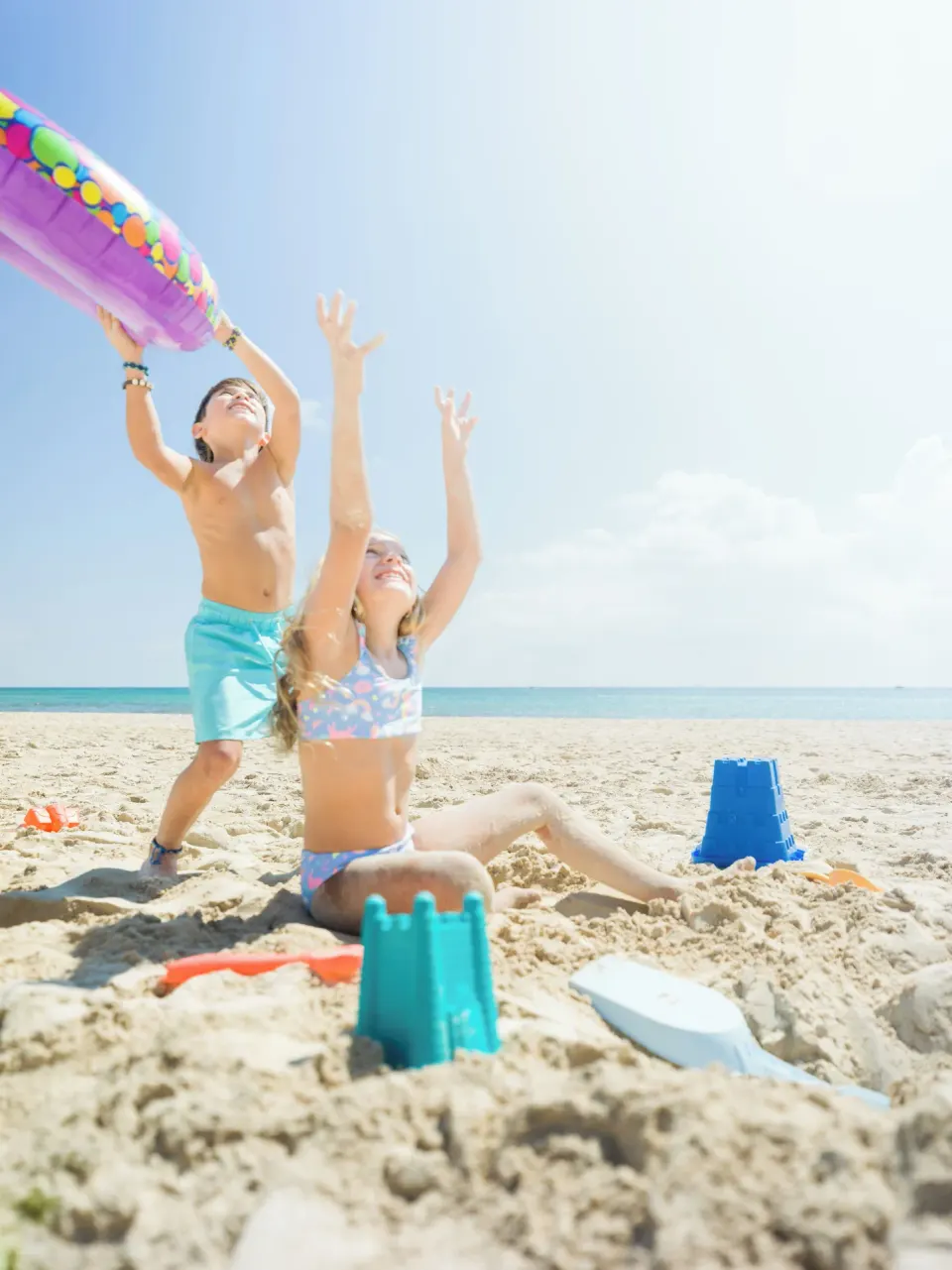 Children playing with an inflatable and sand toys on the sunny beach at Melia Cozumel