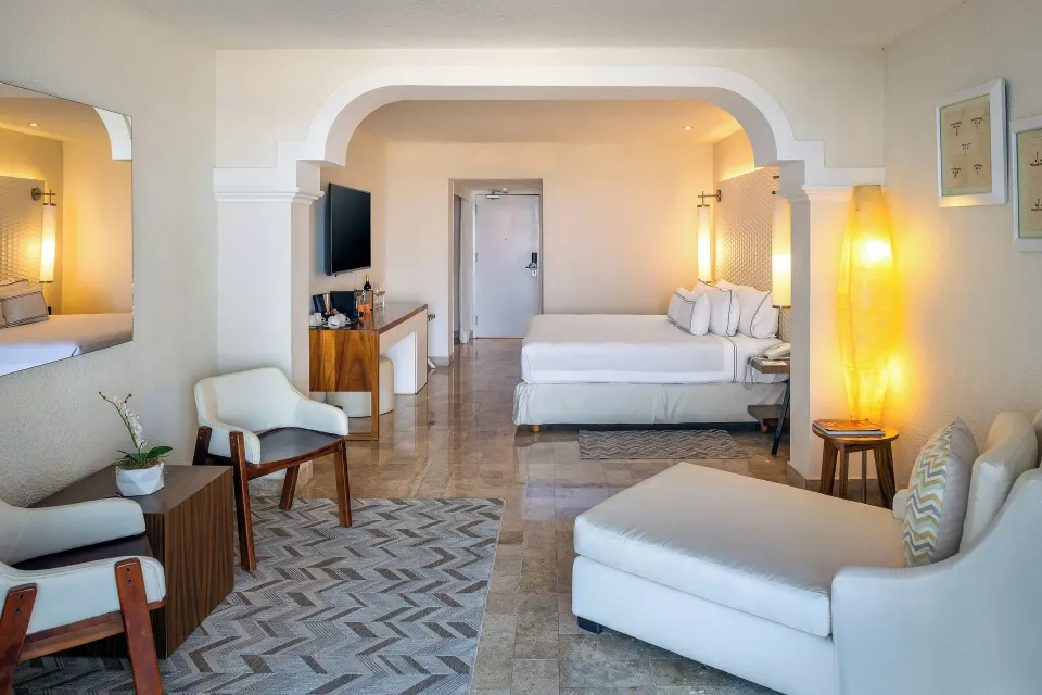 Large suite with open-plan living area, chaise lounge and king bed at Melia Cozumel