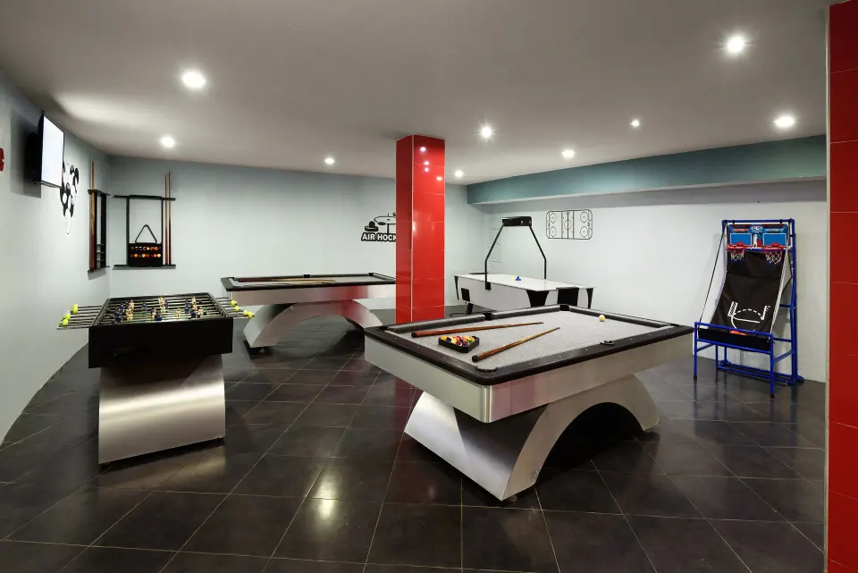 Indoor game room with pool tables and arcade games at Melia Cozumel