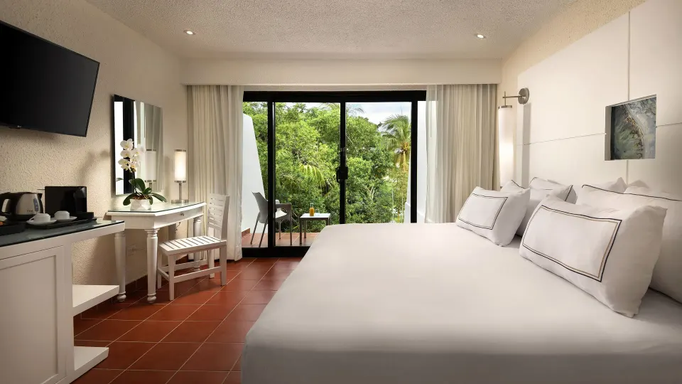 Balcony garden-view room with king bed and desk at Melia Cozumel.