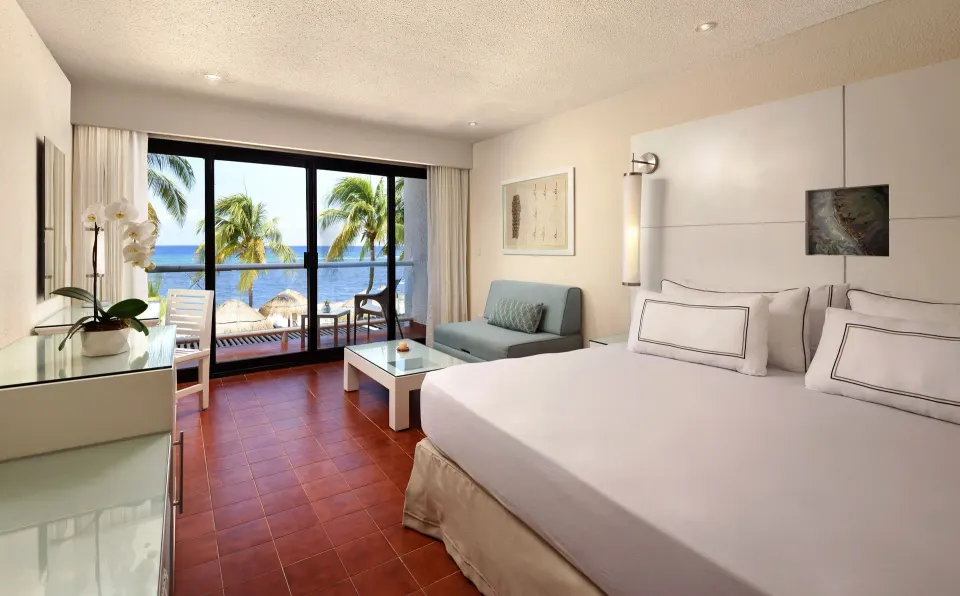 Ocean-view room with king bed, seating area and balcony at Melia Cozumel.