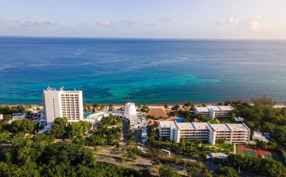 Aerial view of Melia Cozumel resort beachfront and pools along the turquoise sea.