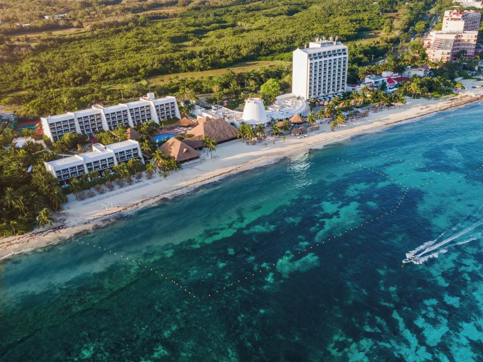 Seaside aerial shot of the Melia Cozumel resort and a boat near the reef
