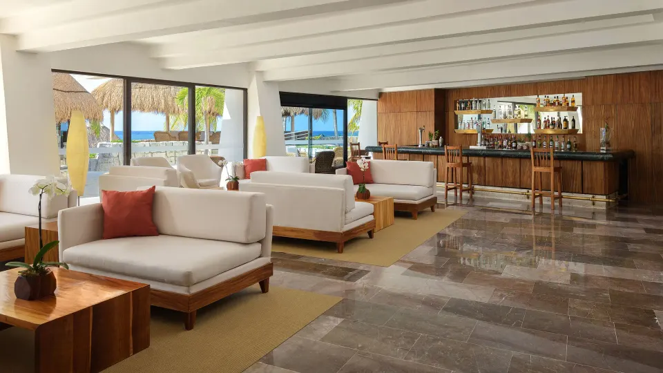 Bright lounge area with bar and ocean views at Melia Cozumel