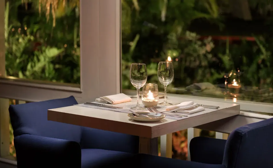 Intimate table set for two by a window at Melia Cozumel