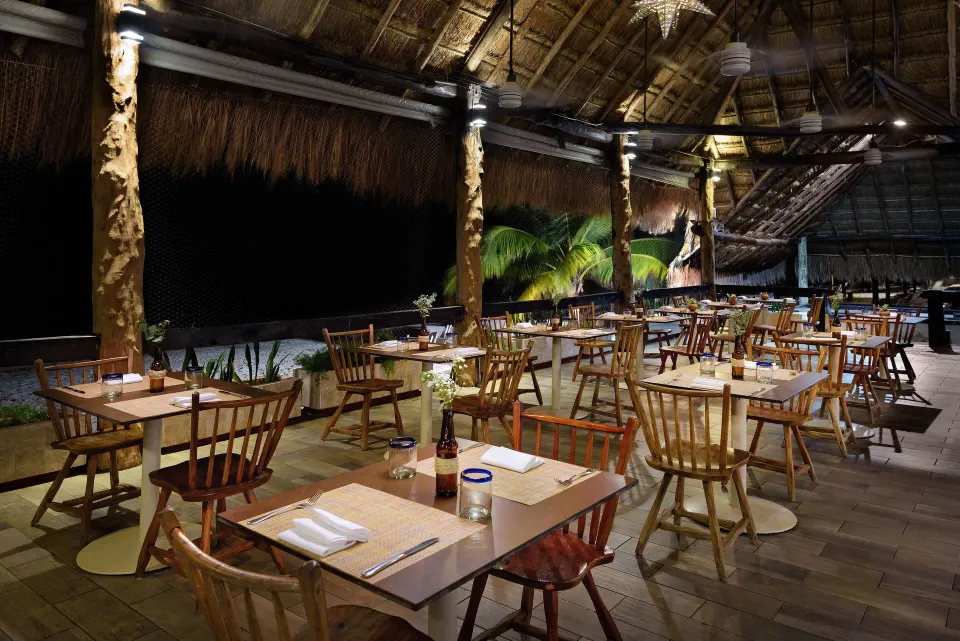 Open-air beachfront dining under a palapa at Melia Cozumel