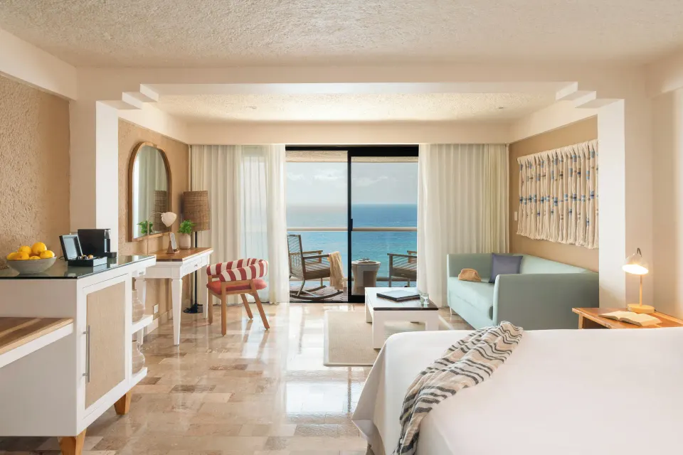 Junior Suite oceanfront room with king bed, seating area and balcony at Melia Cozumel