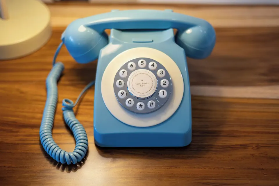 Close-up of a blue rotary-style telephone in a ZEL House Ocean Front guest room at Melia Cozumel