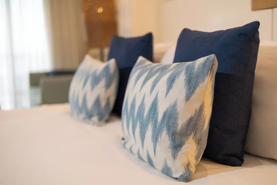 Close-up of decorative pillows on the king bed in a ZEL Premier Suite Ocean Front at Melia Cozumel