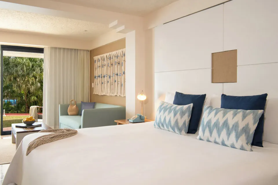ZEL Room Garden View at Melia Cozumel showing king bed, sofa and sliding glass door to garden