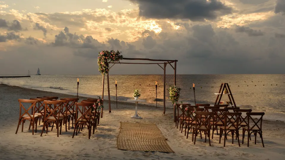 Beach wedding arch and rows of chairs set on the sand at Melia Cozumel