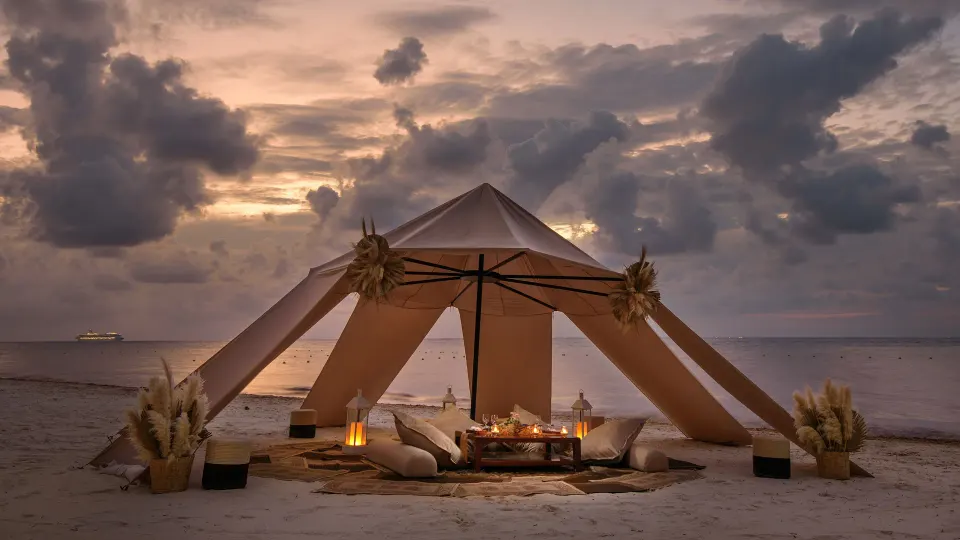 Large romantic beach tent setup at dusk on Melia Cozumel beach