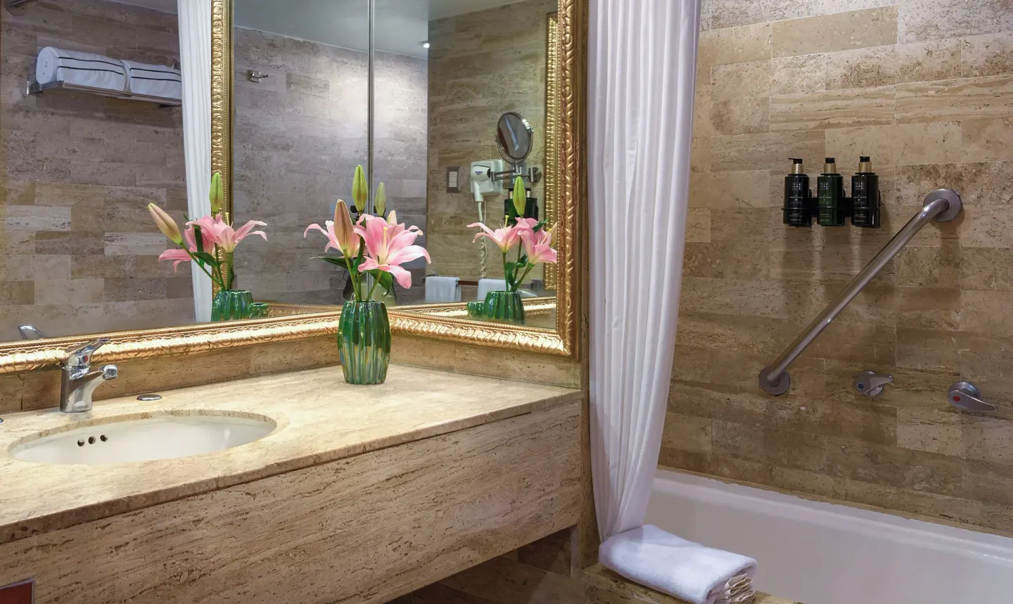 Bathroom vanity and tub with flowers and bath amenities at Melia Puerto Vallarta.