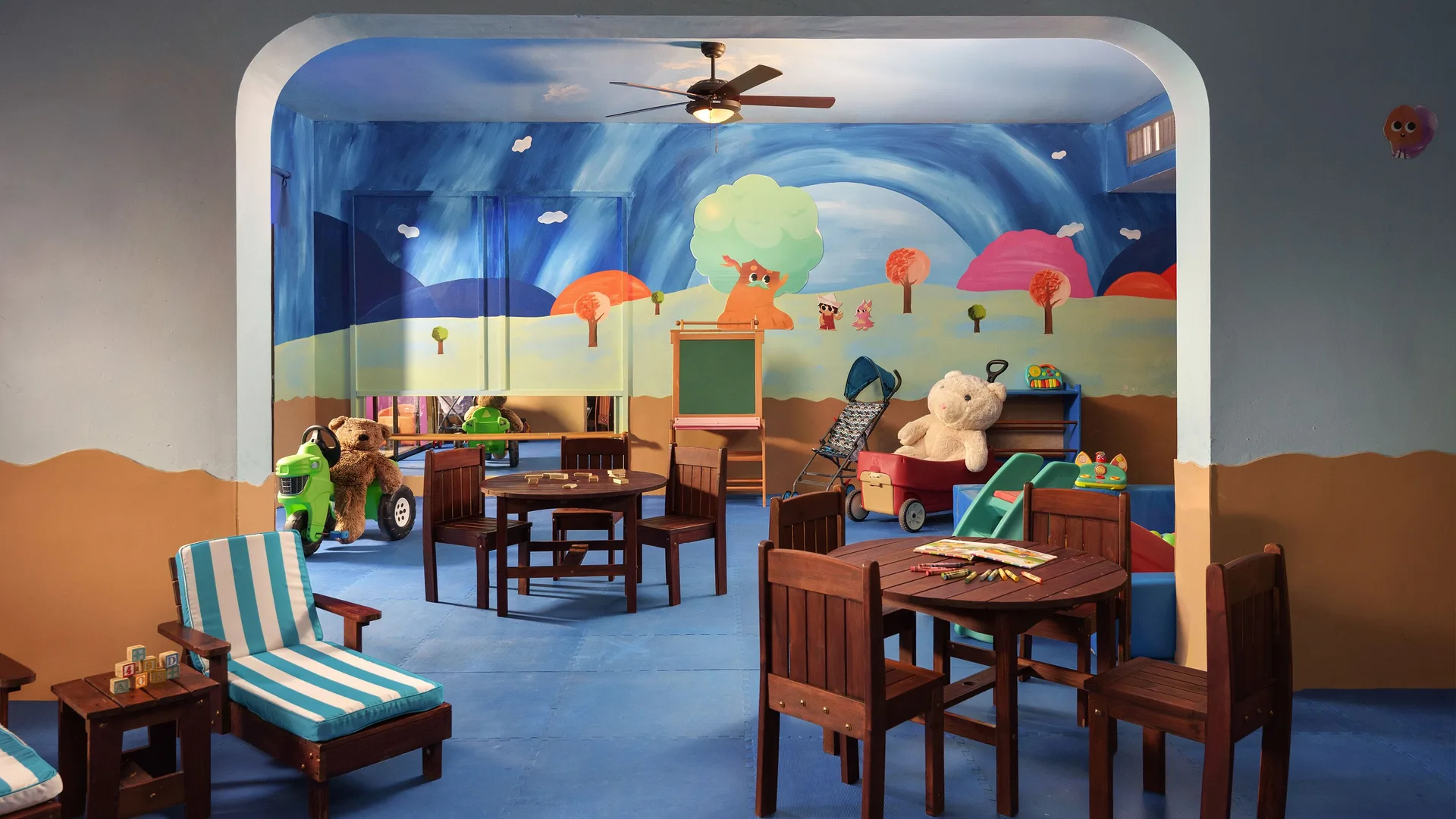 Indoor children’s playroom with murals, toys, and small tables at Melia Puerto Vallarta.