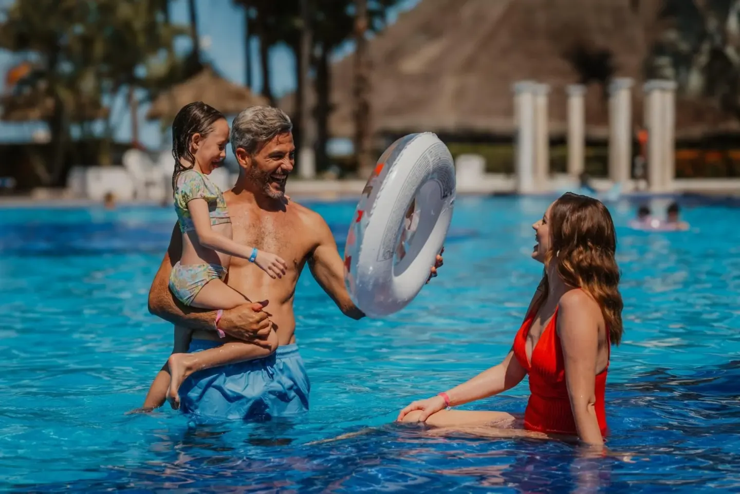 Family playing with an inflatable ring in the pool at Melia Puerto Vallarta.