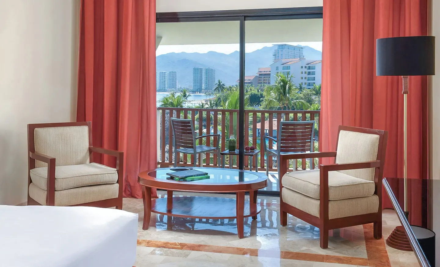 Guest room seating area by a balcony with mountain views at Melia Puerto Vallarta.