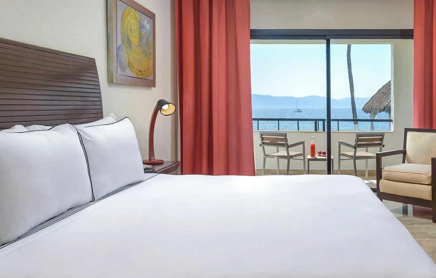 King bed guest room with ocean-view balcony at Melia Puerto Vallarta.