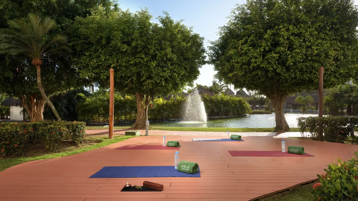 Outdoor yoga mats on a deck by a lagoon fountain at Melia Puerto Vallarta.