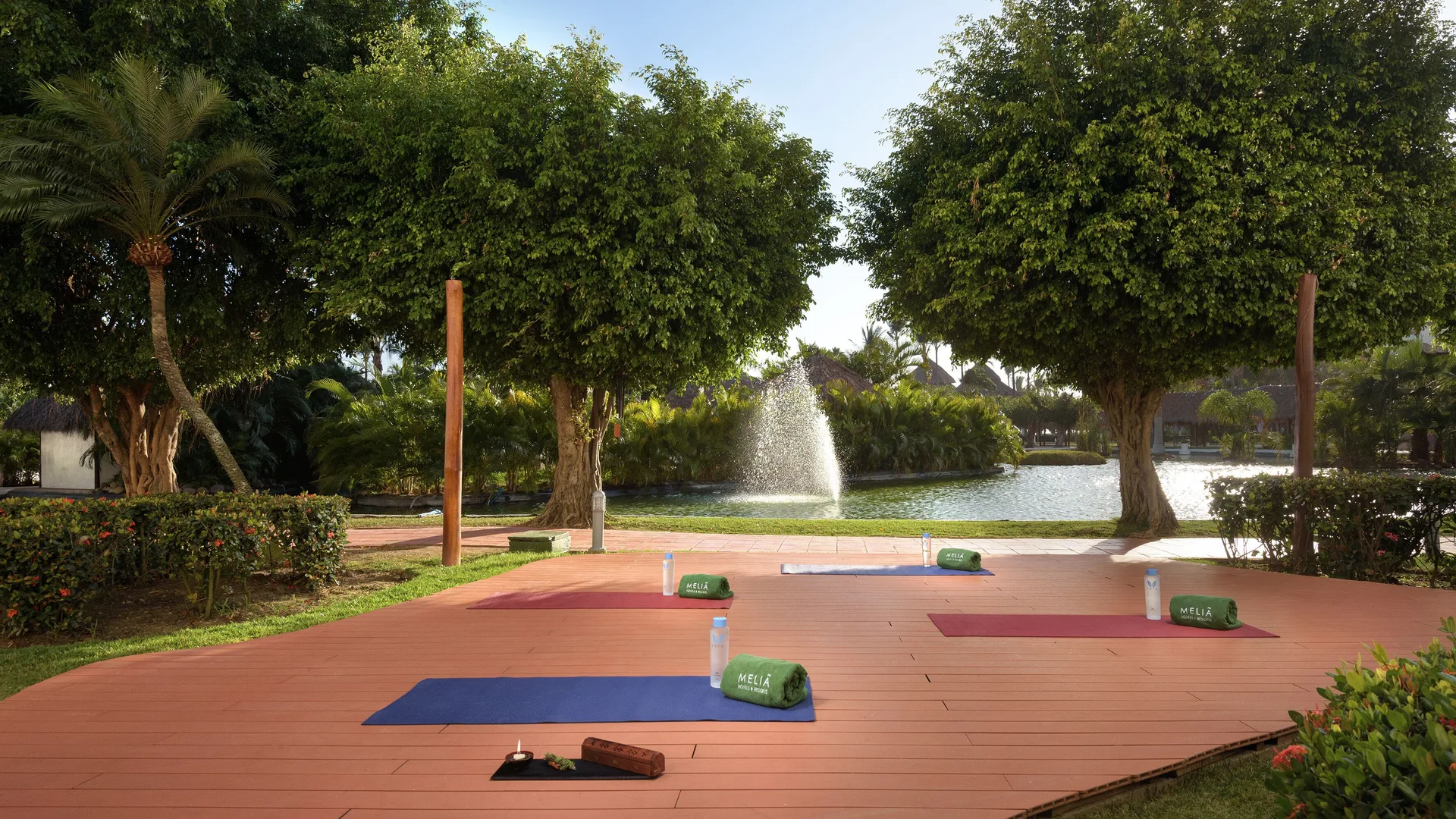 Outdoor yoga mats on a deck by a lagoon fountain at Melia Puerto Vallarta.