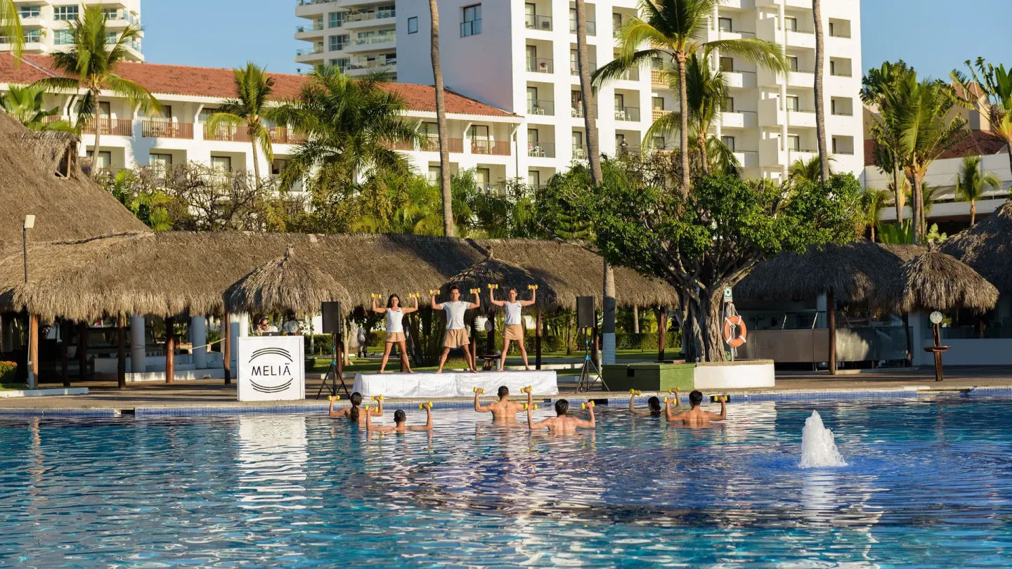 Pool fitness class with instructors on a platform at Melia Puerto Vallarta.