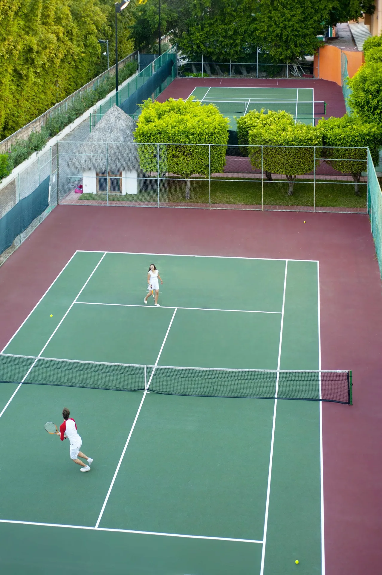 Guests play tennis on resort courts at Melia Puerto Vallarta.