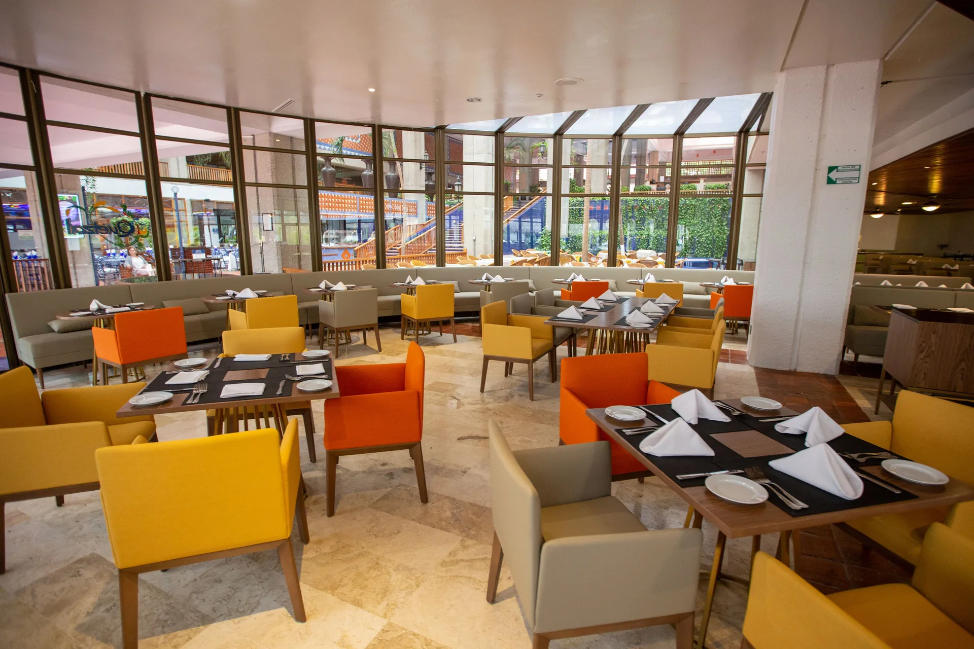 Bright restaurant dining room with yellow and orange chairs at Melia Puerto Vallarta.