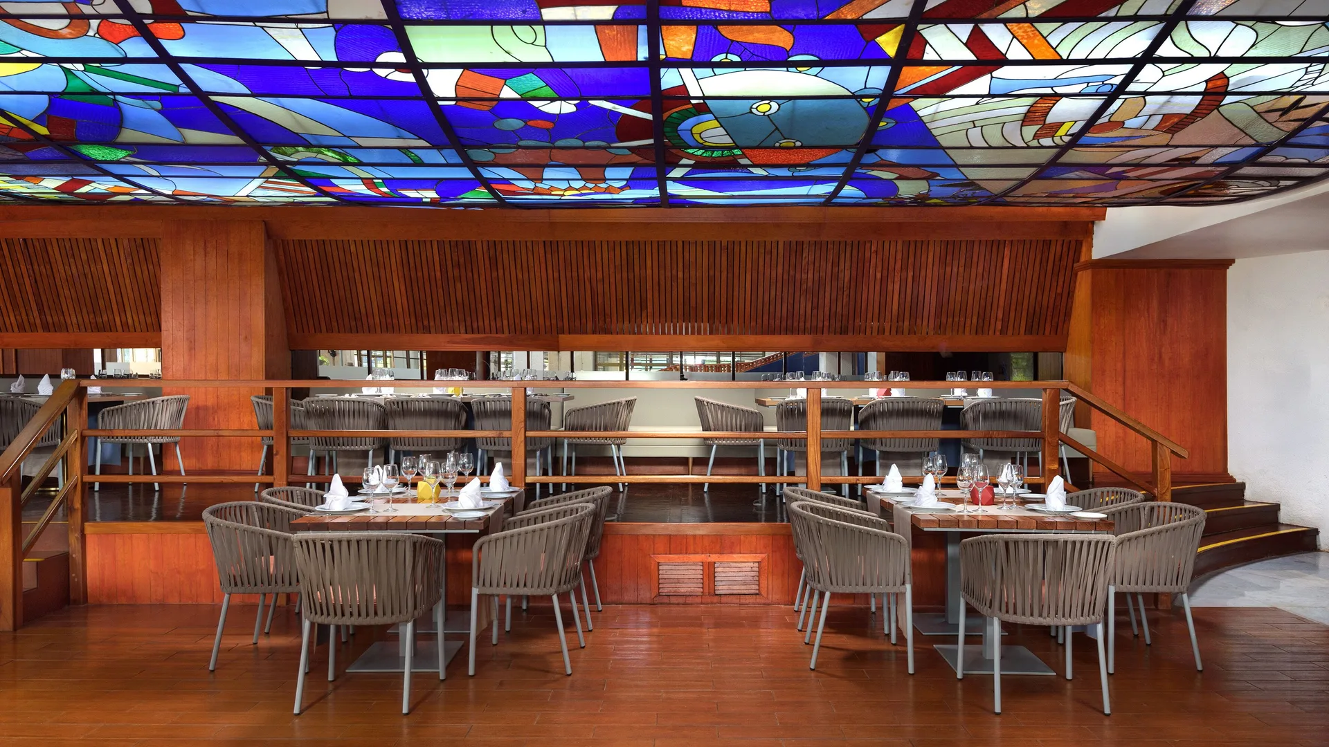 Dining room with stained-glass ceiling and set tables at Melia Puerto Vallarta.