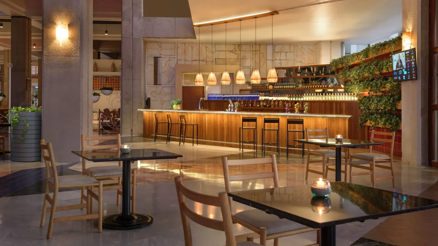 Lobby bar with wood counter and café tables at Melia Puerto Vallarta.