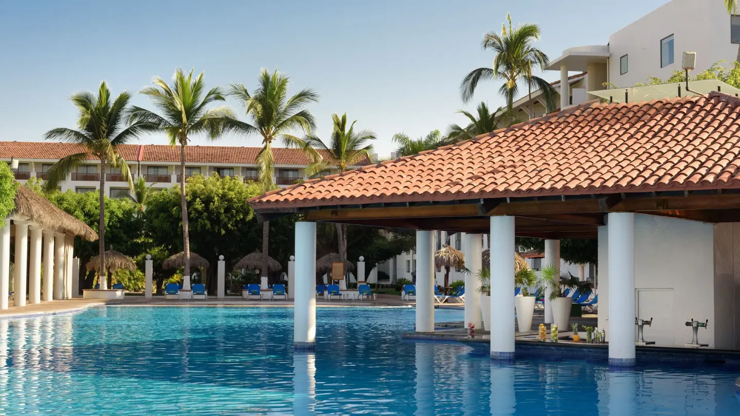 Poolside swim-up bar with red tile roof and white columns at Melia Puerto Vallarta.