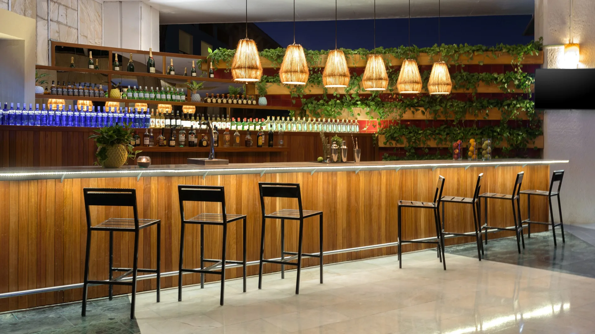 Wood-front bar with stools and pendant lights at Melia Puerto Vallarta.