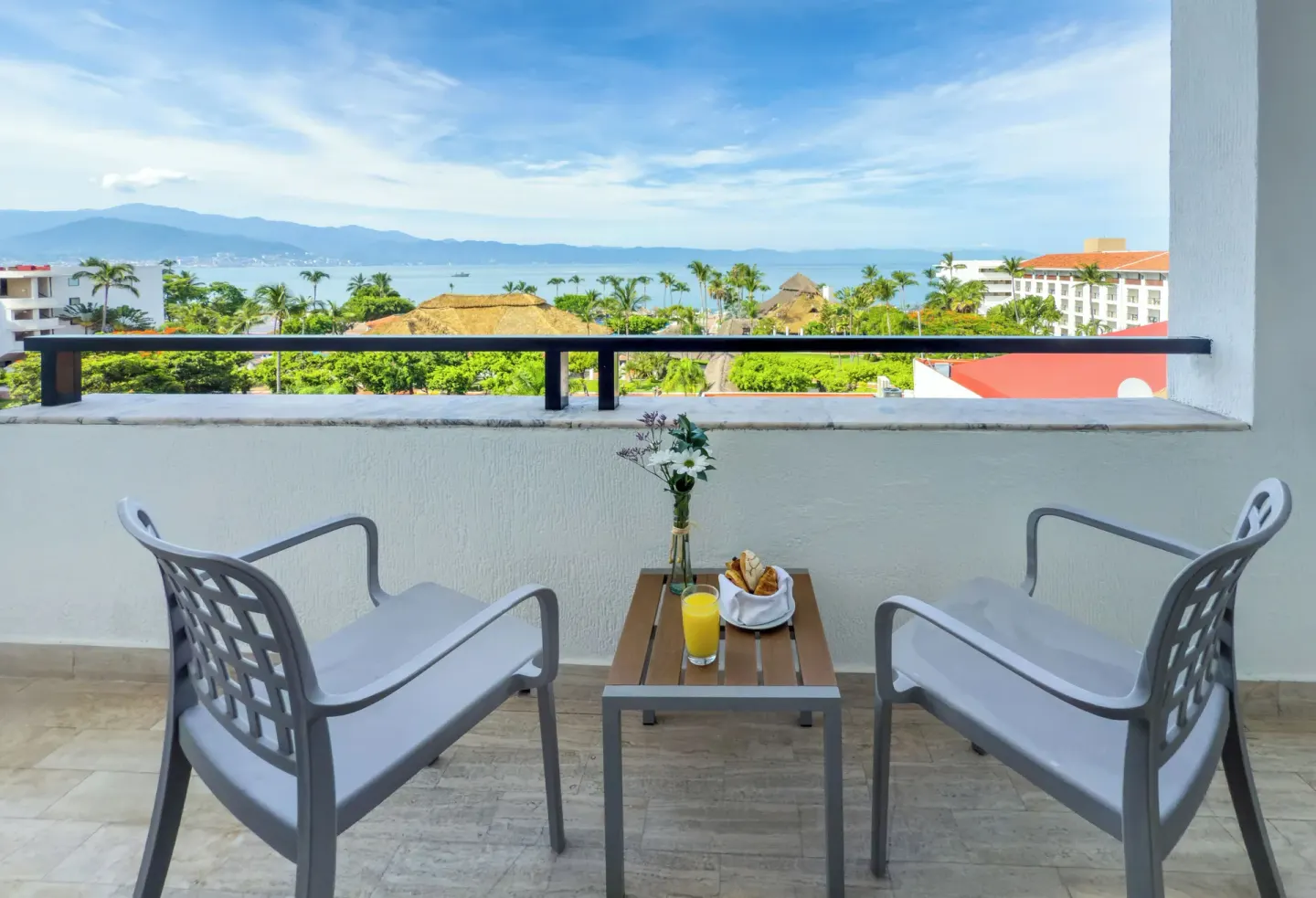 Deluxe Room Sea View balcony with chairs and ocean view at Melia Puerto Vallarta.