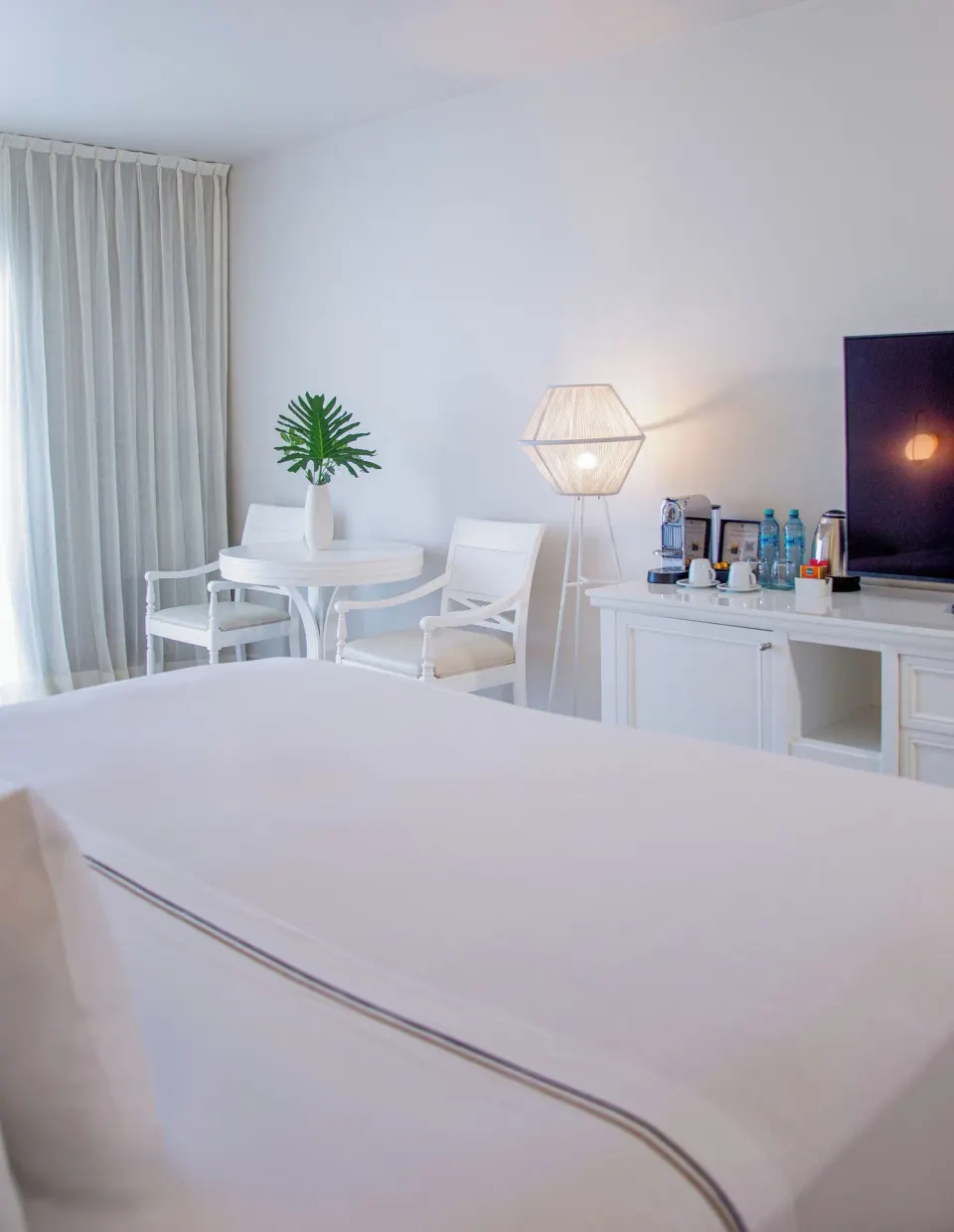 Deluxe Room Sea View king bed with table, TV and refreshment area at Melia Puerto Vallarta.